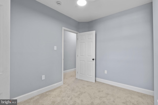 spare room featuring light colored carpet