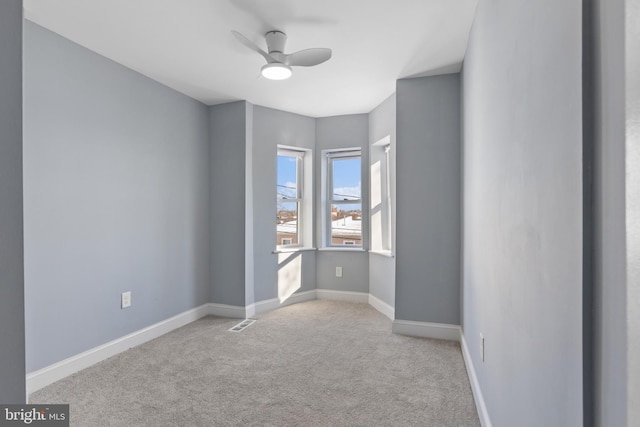 carpeted spare room featuring ceiling fan