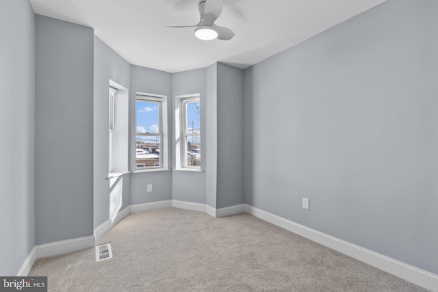 spare room with ceiling fan and light colored carpet