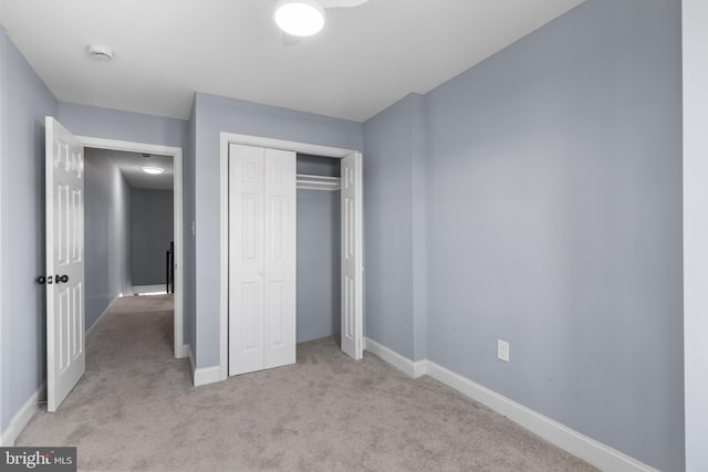 unfurnished bedroom featuring light colored carpet and a closet