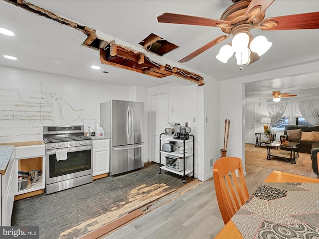 kitchen with ceiling fan, white cabinets, light wood-type flooring, and appliances with stainless steel finishes