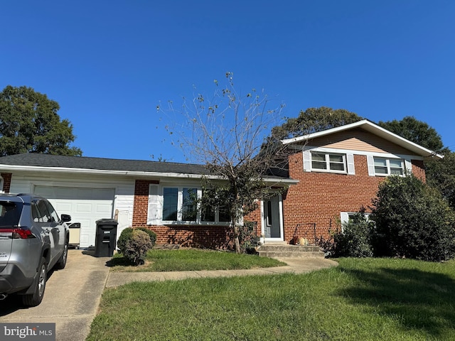 tri-level home with a garage, driveway, a front lawn, and brick siding