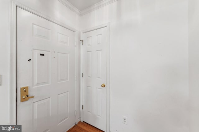 doorway with hardwood / wood-style floors and ornamental molding