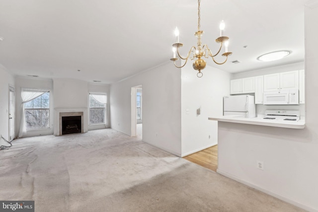 unfurnished living room featuring a notable chandelier and light colored carpet