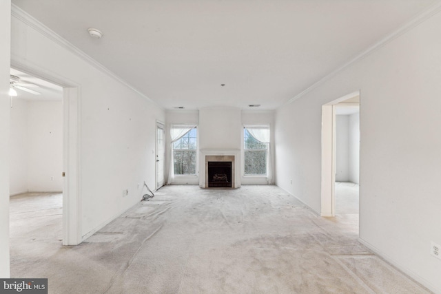 unfurnished living room featuring ceiling fan, light colored carpet, and crown molding