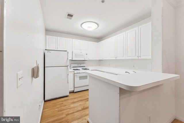 kitchen with kitchen peninsula, white cabinets, light hardwood / wood-style floors, and white appliances