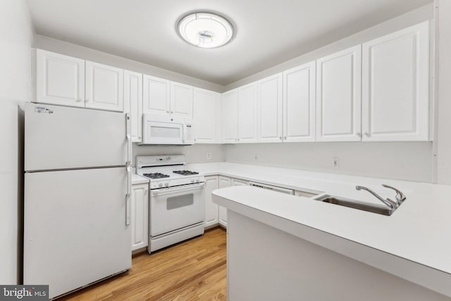 kitchen with white appliances, light hardwood / wood-style floors, white cabinetry, and sink