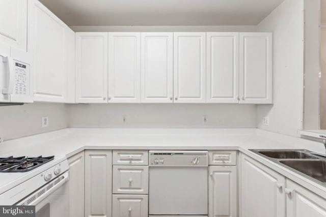 kitchen with white cabinets, white appliances, and sink