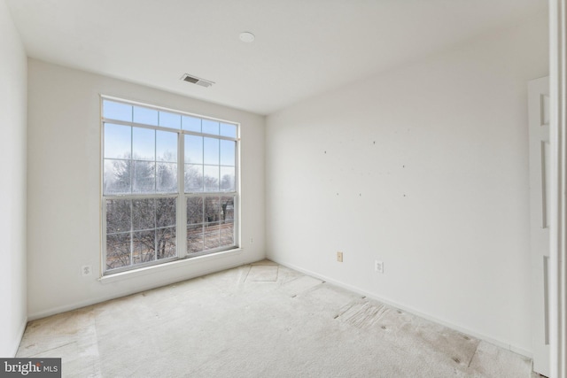 spare room featuring light colored carpet