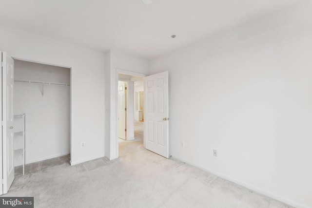 unfurnished bedroom with light carpet and a closet