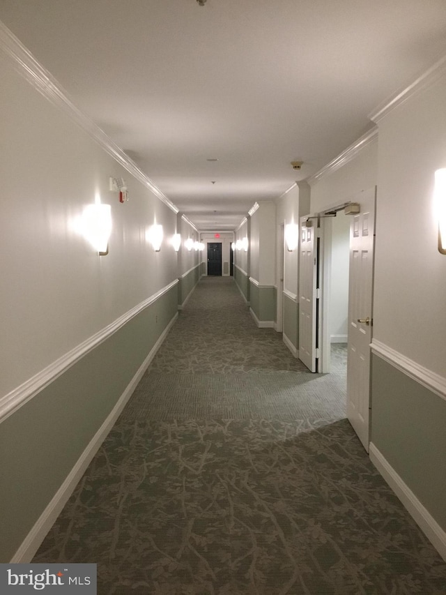 corridor featuring dark carpet and ornamental molding