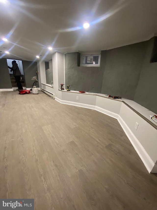 basement with hardwood / wood-style floors and a baseboard heating unit