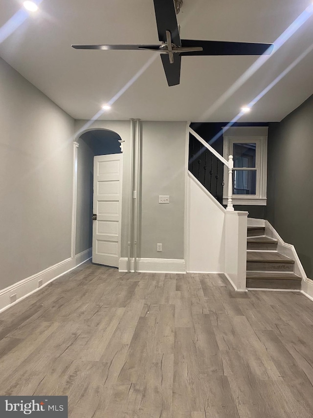 basement featuring light hardwood / wood-style flooring and ceiling fan