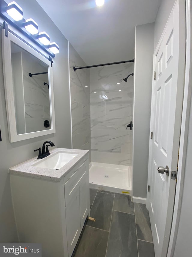 bathroom featuring vanity and tiled shower