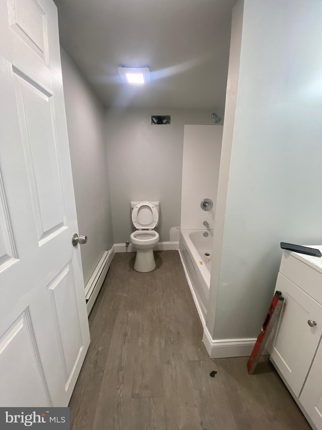 bathroom with a bathtub, vanity, a baseboard radiator, hardwood / wood-style floors, and toilet