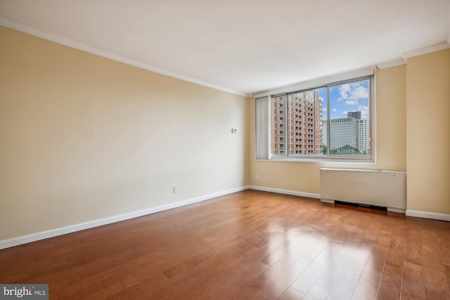 empty room featuring light hardwood / wood-style floors and ornamental molding