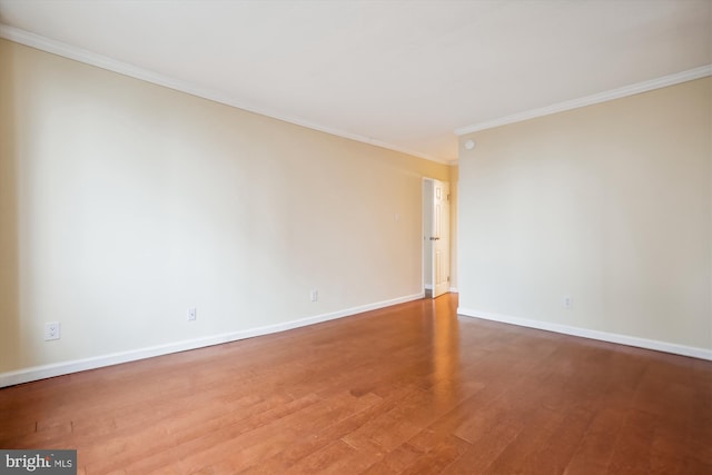 empty room featuring ornamental molding and hardwood / wood-style flooring