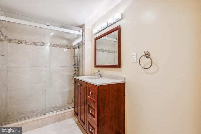 bathroom with tile patterned floors, a shower with door, and vanity