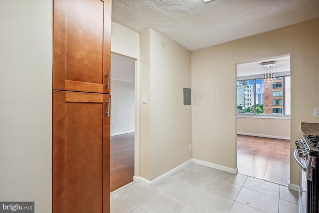 hallway featuring light tile patterned floors and a textured ceiling