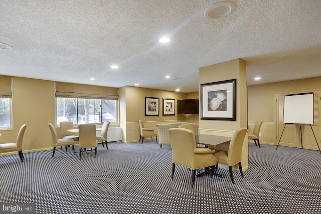 dining space featuring carpet flooring and a textured ceiling