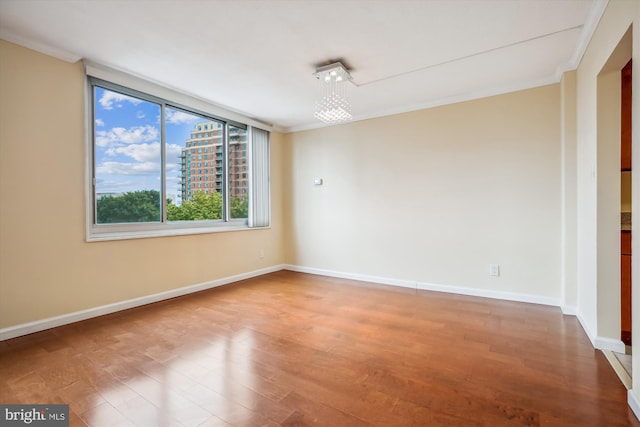 empty room featuring crown molding and hardwood / wood-style floors