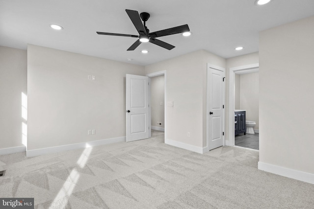 unfurnished bedroom with connected bathroom, light colored carpet, and ceiling fan