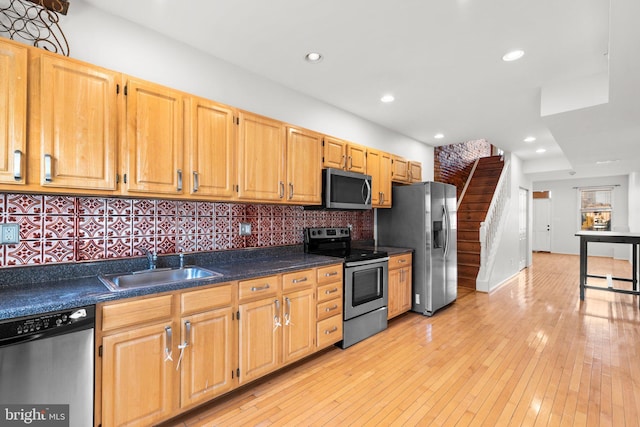 kitchen with light brown cabinets, sink, decorative backsplash, light hardwood / wood-style floors, and stainless steel appliances