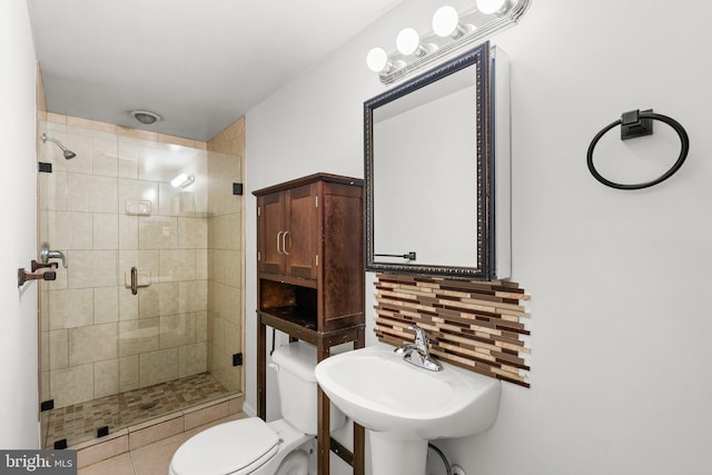 bathroom featuring sink, tile patterned flooring, decorative backsplash, toilet, and an enclosed shower