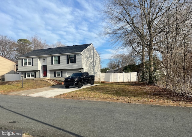 bi-level home featuring a garage and a front lawn