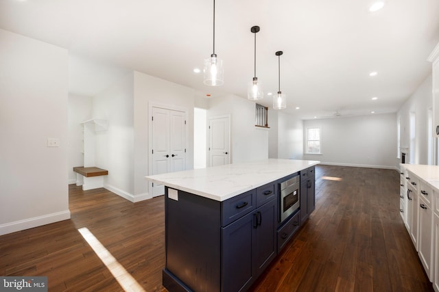 kitchen featuring dark hardwood / wood-style flooring, ceiling fan, decorative light fixtures, white cabinets, and stainless steel microwave