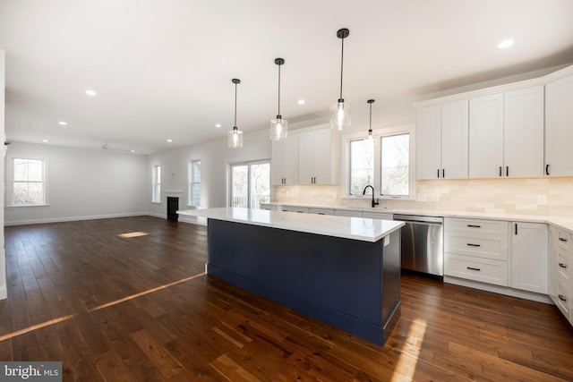 kitchen featuring white cabinets, dark hardwood / wood-style flooring, a center island, and stainless steel dishwasher