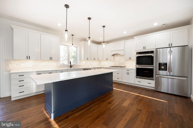 kitchen with a kitchen island, dark hardwood / wood-style flooring, white cabinetry, and appliances with stainless steel finishes