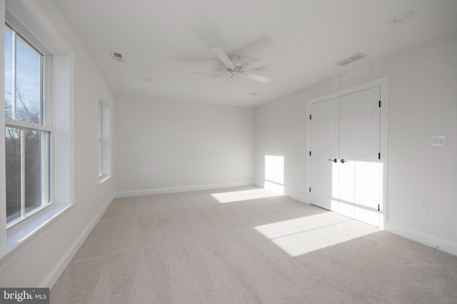 spare room featuring light carpet and ceiling fan