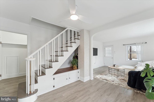 stairway with hardwood / wood-style flooring and ceiling fan