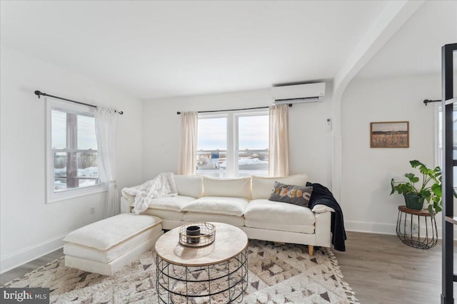 living room featuring light wood-type flooring and a wall unit AC