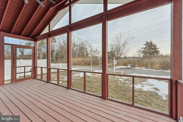 unfurnished sunroom with vaulted ceiling with beams, a wealth of natural light, and wooden ceiling