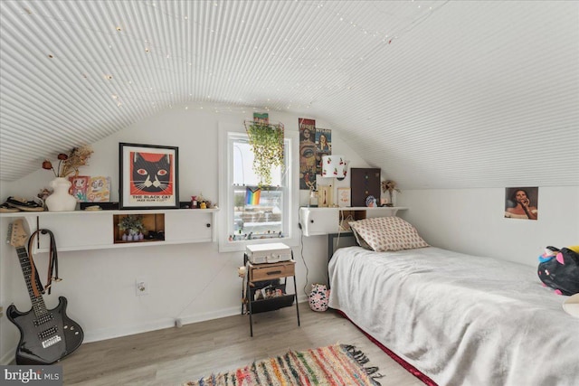 bedroom with vaulted ceiling and light wood-type flooring