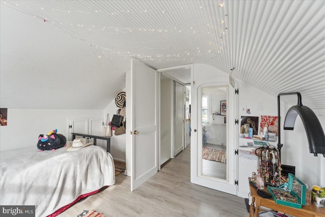 bedroom with lofted ceiling and light hardwood / wood-style flooring