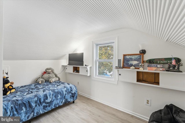 bedroom with light hardwood / wood-style floors and vaulted ceiling