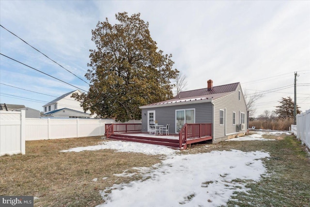 snow covered property with a wooden deck and a yard