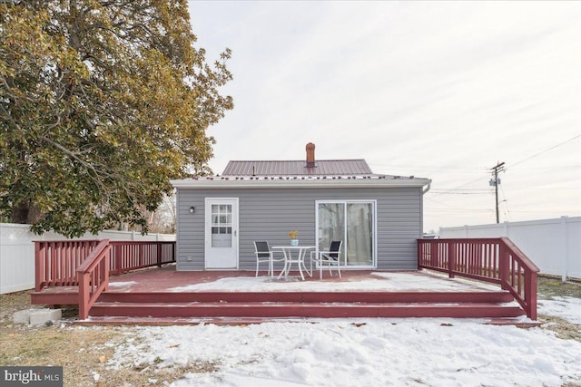 snow covered rear of property featuring a deck