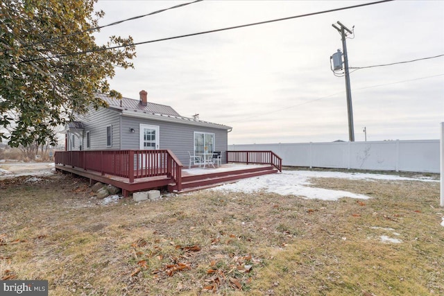 back of house featuring a lawn and a deck