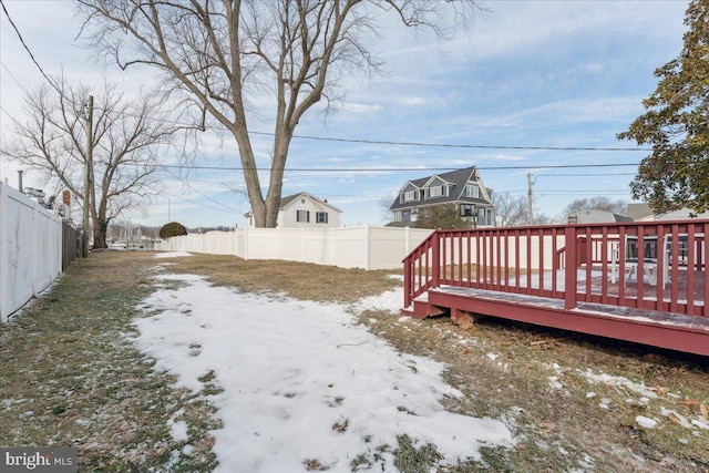 yard covered in snow with a deck