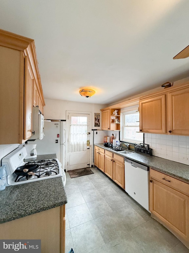 kitchen with tasteful backsplash, sink, a healthy amount of sunlight, and white appliances