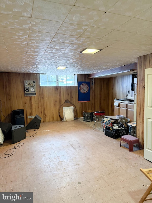 basement featuring wooden walls