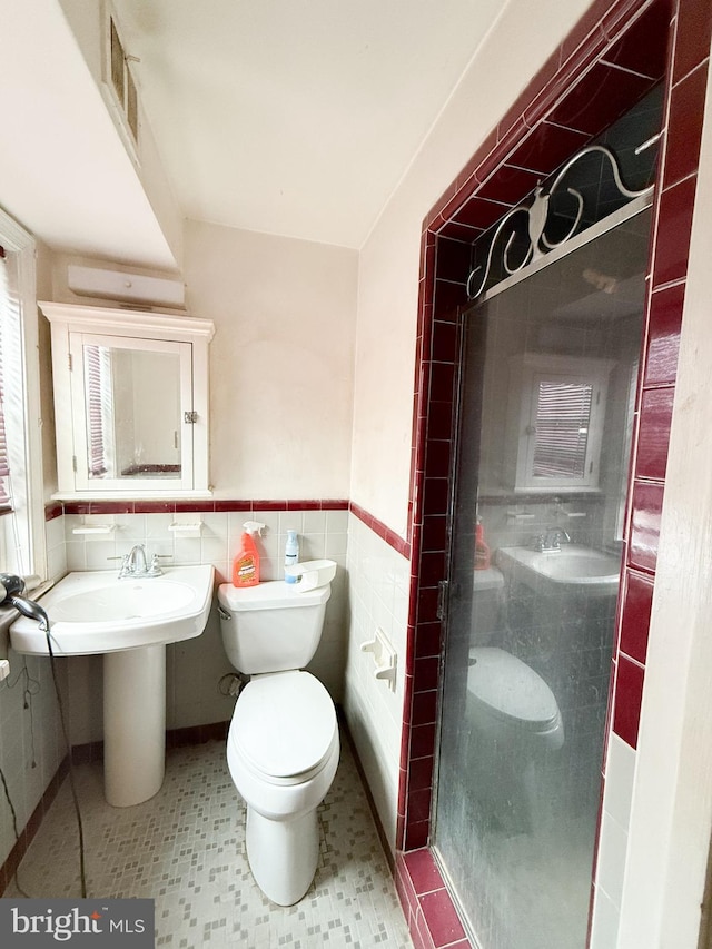 bathroom with a tile shower, tile walls, and toilet