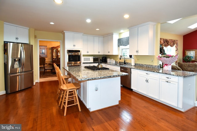 kitchen featuring appliances with stainless steel finishes, white cabinetry, and dark wood-type flooring