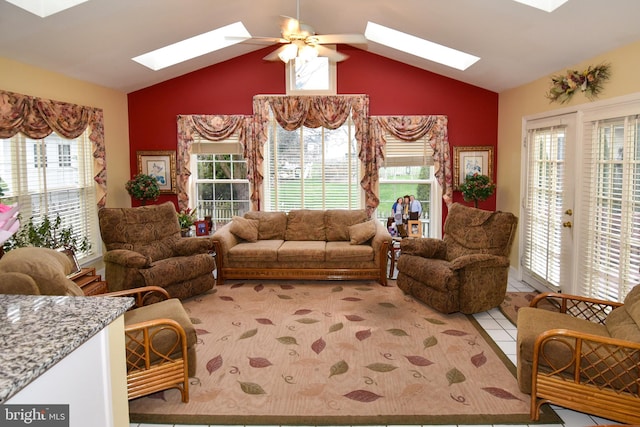 living room featuring ceiling fan, light tile patterned flooring, a healthy amount of sunlight, and lofted ceiling