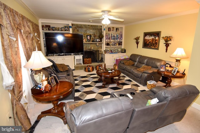 carpeted living room featuring ceiling fan, a stone fireplace, and ornamental molding