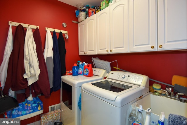 laundry area with cabinets, washing machine and dryer, and sink